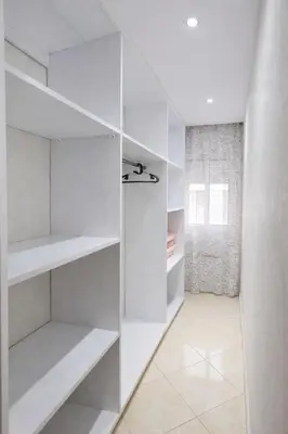 a white walk in closet with white shelves at Cozy appartement à Mohammedia in Mohammedia