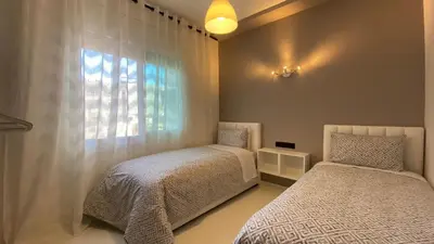 a bedroom with two beds and a window at RABAT RESIDENCE - Apartments in Rabat