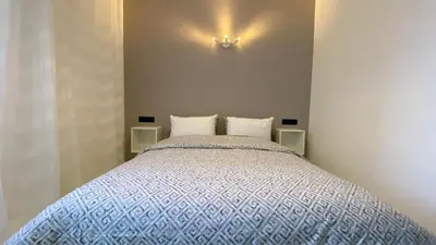 a bedroom with a bed with a blue comforter at RABAT RESIDENCE - Apartments in Rabat