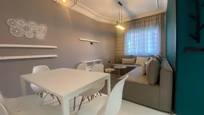 a living room with a table and chairs and a couch at RABAT RESIDENCE - Apartments in Rabat