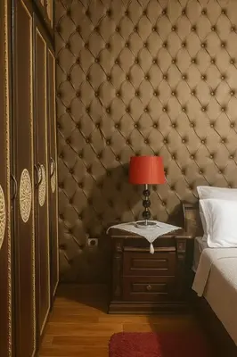 a bedroom with a wall with a bed and a table with a lamp at Luxury duplex in the centre of Maarif in Casablanca