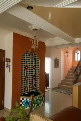 a living room with a staircase and a chandelier at Luxury duplex in the centre of Maarif in Casablanca