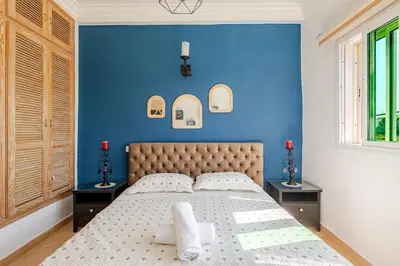 a bedroom with blue walls and a bed with two windows at 4 min à pied de la Plage, 3 BR, Piscine, Parking in Skhirat
