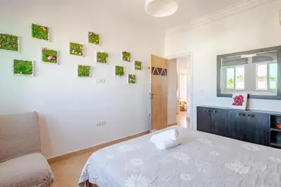 a bedroom with a bed and some pictures on the wall at 4 min à pied de la Plage, 3 BR, Piscine, Parking in Skhirat