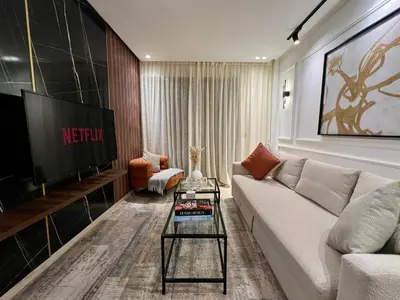 a living room with a couch and a tv at Cozy Studio à Palmier avec Roof top et Parking in Casablanca