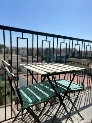 a picnic table and a chair on a balcony at Cozy Studio à Palmier avec Roof top et Parking in Casablanca