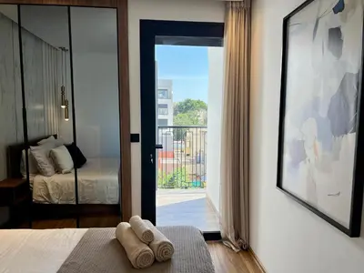a bedroom with a bed and a door to a balcony at Cozy Studio à Palmier avec Roof top et Parking in Casablanca