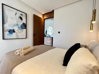 a bedroom with a large bed with two towels on it at Cozy Studio à Palmier avec Roof top et Parking in Casablanca