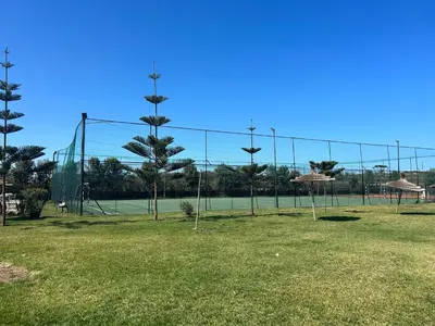 a batting cage with palm trees in a field at Savannah beach sidi Rahal in Dar Hamida