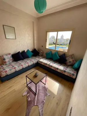a living room with a couch and a table at Savannah beach sidi Rahal in Dar Hamida