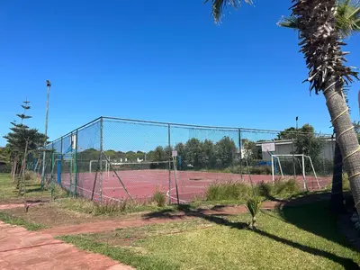 a tennis court with a net on a tennis court at Savannah beach sidi Rahal in Dar Hamida