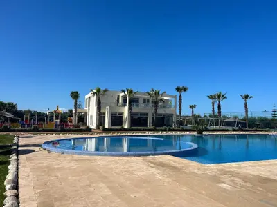 a large swimming pool in front of a house at Savannah beach sidi Rahal in Dar Hamida