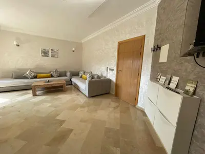 a living room with a couch and a table at Savannah beach sidi Rahal in Dar Hamida