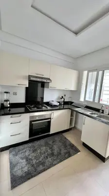 a kitchen with white cabinets and a stove top oven at N9 Appartement pied sur mer, La Corniche Rabat in Rabat