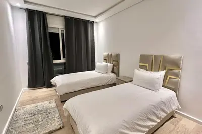 a hotel room with two beds and a window at N9 Appartement pied sur mer, La Corniche Rabat in Rabat