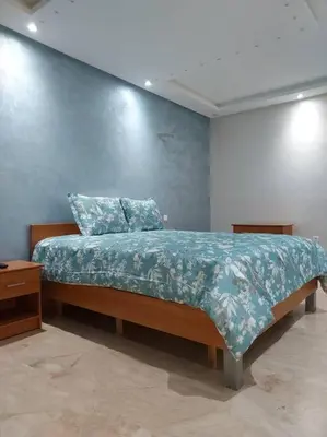 a bedroom with a bed with a blue wall at Beautiful 3BR apartment in Hay Riad Rabat in Rabat