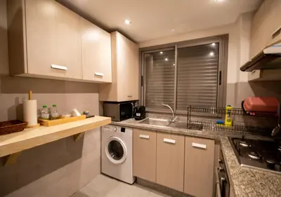 a kitchen with a sink and a washing machine at R101- Cosy and stylish apartment with King Size Bed- Belvédère in Casablanca