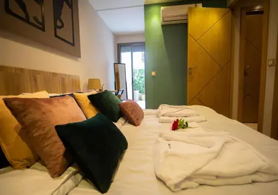 a bed with blankets and pillows on top of it at R101- Cosy and stylish apartment with King Size Bed- Belvédère in Casablanca