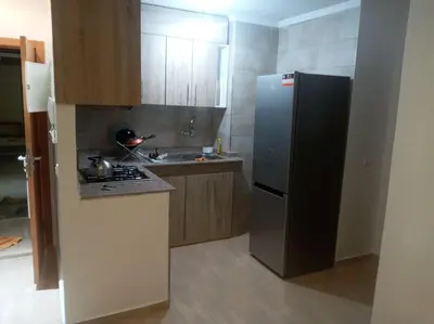 a kitchen with a stainless steel refrigerator and a sink at Cocon cozy à Mansouria Mer, piscines et nature in Mansouria