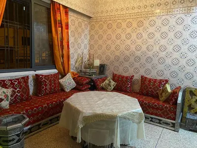 a living room with a red couch and a table at Appartement oulfa in Casablanca