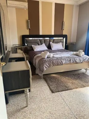 a bedroom with a large bed with a table and a mirror at Grand appartement 3 chambre in Casablanca