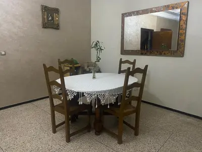 a table and chairs with a table and a mirror at Grand appartement 3 chambre in Casablanca