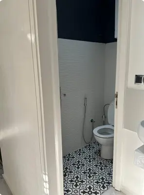 a bathroom with a white toilet and a black and white tile floor at Chambre à Agdal Rabat dans un appartement partagé in Rabat