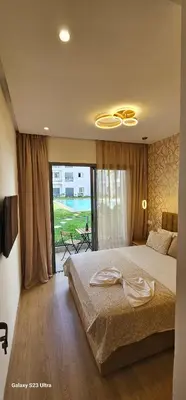 a bedroom with a large bed and a large window at Cosy & Confort Studio près de l'aéroport in Nouaceur