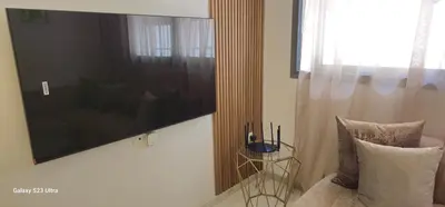 a living room with a large television and a couch at Cosy & Confort Studio près de l'aéroport in Nouaceur
