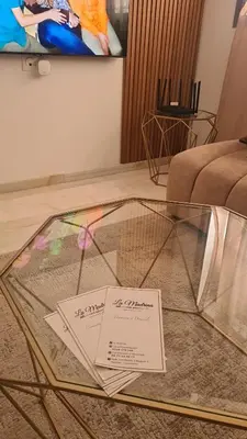 a glass table with a sign on it in a room at Cosy & Confort Studio près de l'aéroport in Nouaceur