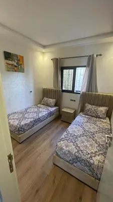 two beds in a room with wooden floors at Modern rez de villa, jack beach Tamaris, Dar Bouaza in Casablanca