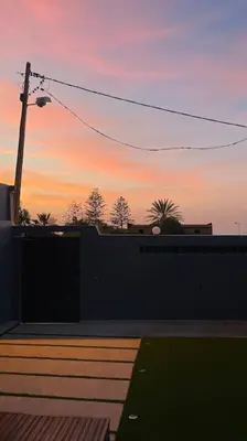 a sunset with a building and a street light at Modern rez de villa, jack beach Tamaris, Dar Bouaza in Casablanca