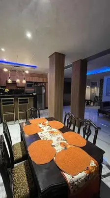 a dining room with a table and a kitchen at Modern rez de villa, jack beach Tamaris, Dar Bouaza in Casablanca