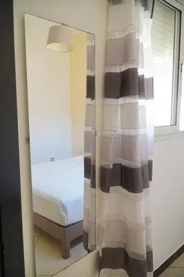 a mirror in a room with a bed and a window at Le Calme a Temara in Temara