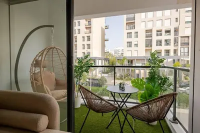 a balcony with a hammock and a table and chairs at TT Holidays Hay Riad Prestigia in Rabat