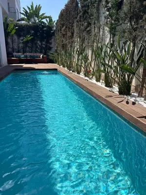 a swimming pool with blue water in front of a building at Villa de Luxe piscine privée in Casablanca