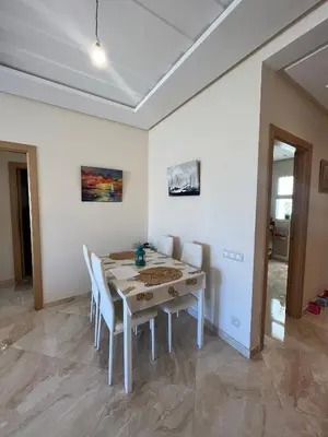 a white dining room with a white table and chairs at Shems Bouznika kettani in Bouznika