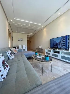 a living room with a couch and a flat screen tv at Shems Bouznika kettani in Bouznika