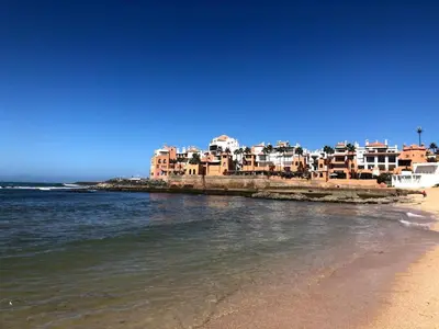 a view of a beach with buildings and the water at Shems Bouznika kettani in Bouznika
