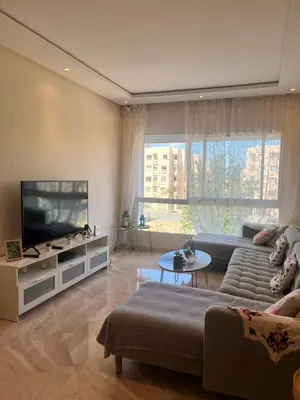a living room with a couch and a flat screen tv at Shems Bouznika kettani in Bouznika