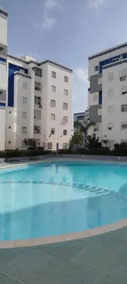 a large swimming pool in front of two buildings at Sublime Appart Bouznika Pool&View in Bouznika