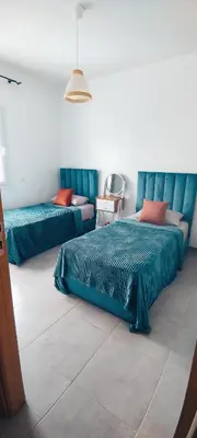 a bedroom with two beds and a couch at Sublime Appart Bouznika Pool&View in Bouznika