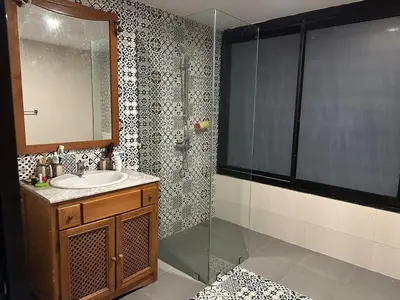 a bathroom with a sink and a glass shower at Appartement loft de luxe dans un quartier Art Déco en plein centre de Casablanca in Casablanca