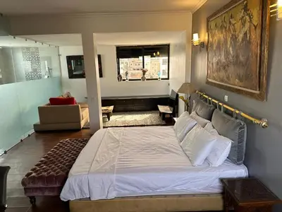 a bedroom with a large bed and a living room at Appartement loft de luxe dans un quartier Art Déco en plein centre de Casablanca in Casablanca