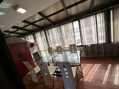 a glass table and chairs in a room with windows at Appartement loft de luxe dans un quartier Art Déco en plein centre de Casablanca in Casablanca