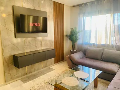 a living room with a couch and a tv at Parc Nouaceur in Nouaseur