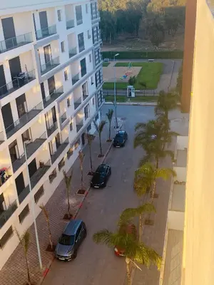 a group of cars parked in a parking lot next to a building at Parc Nouaceur in Nouaseur