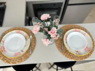 two plates and a vase with flowers on a table at Au centre de Casablanca maarif in Casablanca