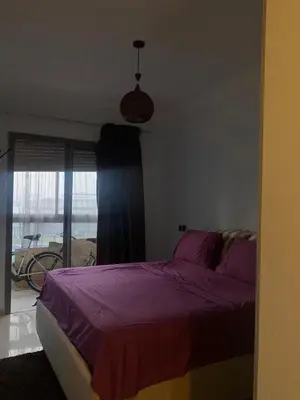 a bedroom with a purple bed and a window at Appartement sur SIDI Rahal in Casablanca