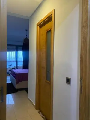 a hallway with a door to a bedroom with a bed at Appartement sur SIDI Rahal in Casablanca